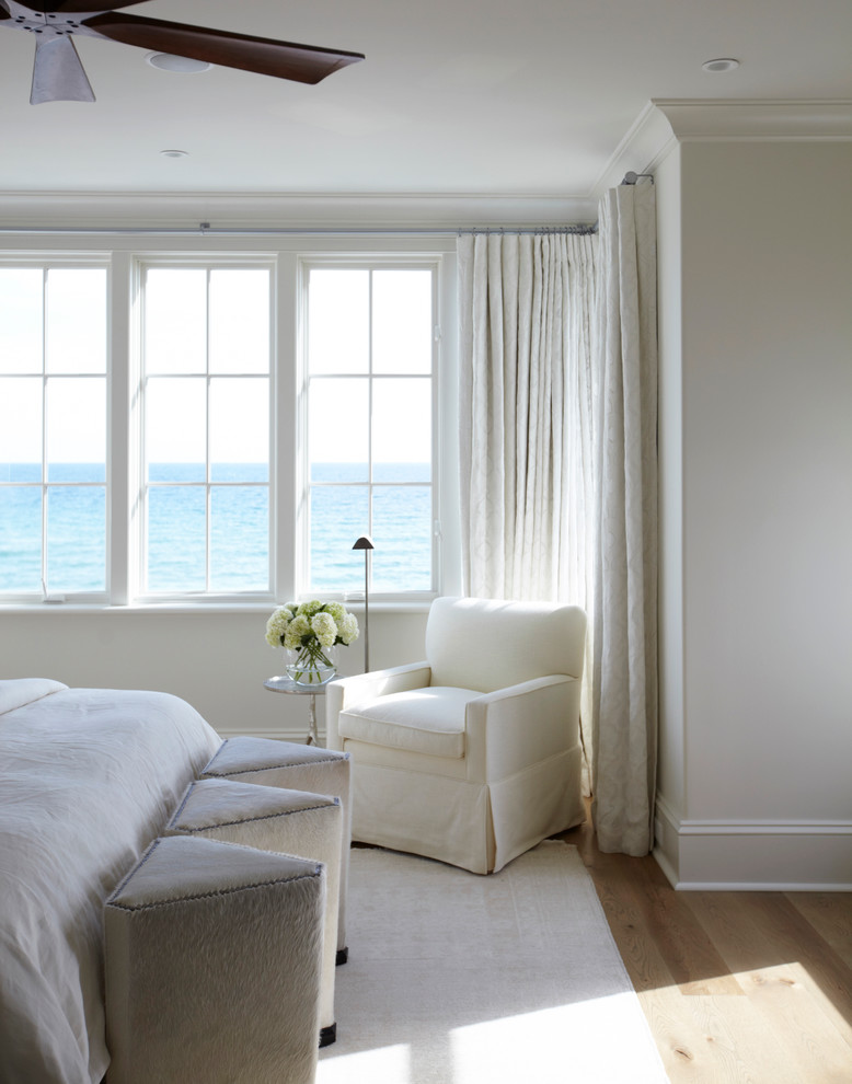 Imagen de dormitorio marinero con paredes blancas y suelo de madera en tonos medios