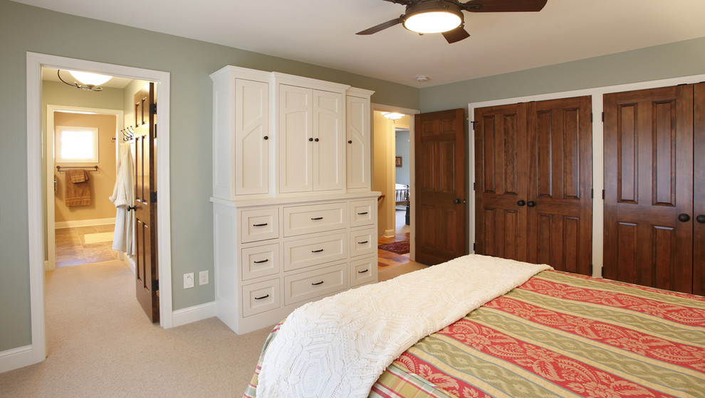 Modelo de dormitorio principal tradicional de tamaño medio con paredes verdes y moqueta