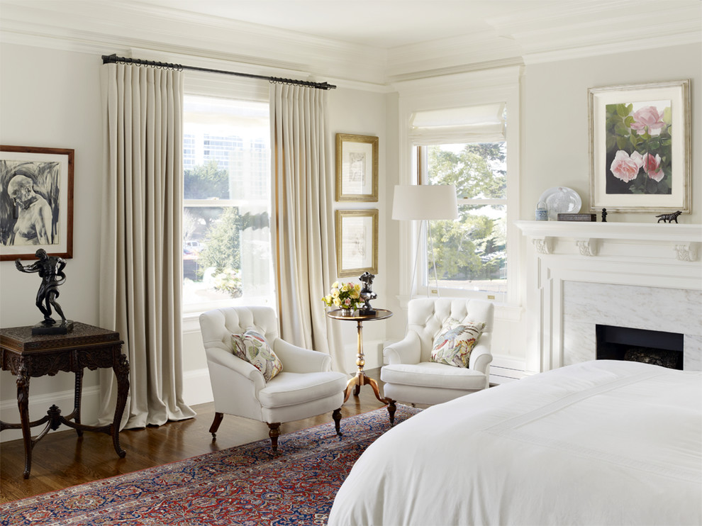 На фото: спальня в классическом стиле с серыми стенами и стандартным камином с