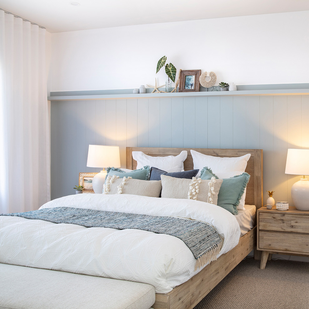 シドニーにある広いビーチスタイルのおしゃれな主寝室 (青い壁、カーペット敷き、暖炉なし、ベージュの床、照明、グレーとクリーム色) のレイアウト