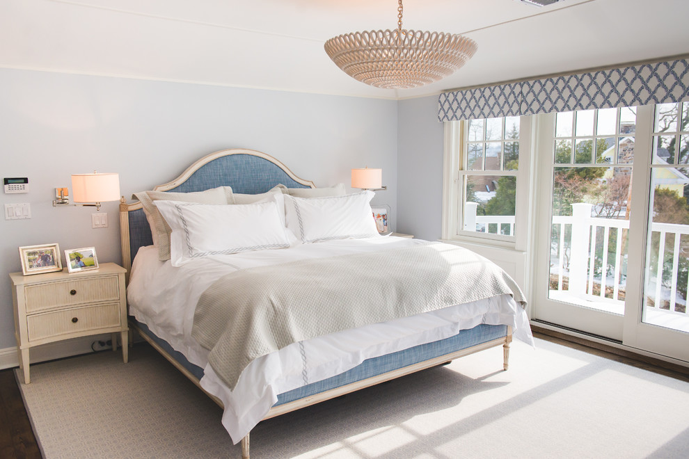 Diseño de dormitorio principal clásico renovado grande con paredes azules, suelo de madera oscura, chimenea lineal y marco de chimenea de piedra
