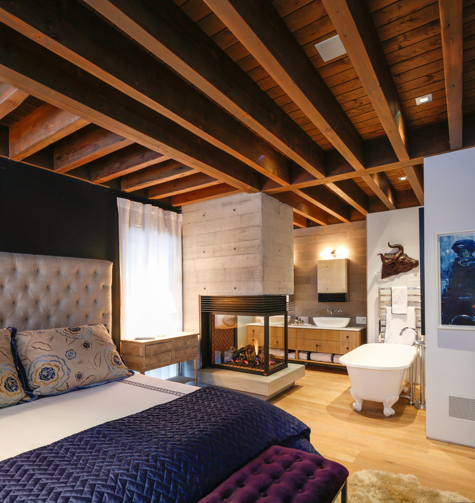 На фото: большая гостевая спальня (комната для гостей) в стиле рустика с разноцветными стенами, светлым паркетным полом, двусторонним камином и фасадом камина из плитки с