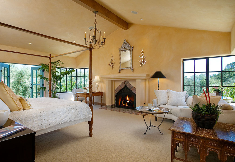 На фото: спальня в классическом стиле с бежевыми стенами, ковровым покрытием и стандартным камином с