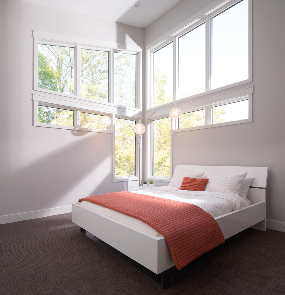 Ejemplo de habitación de invitados contemporánea de tamaño medio sin chimenea con paredes beige, moqueta y suelo marrón