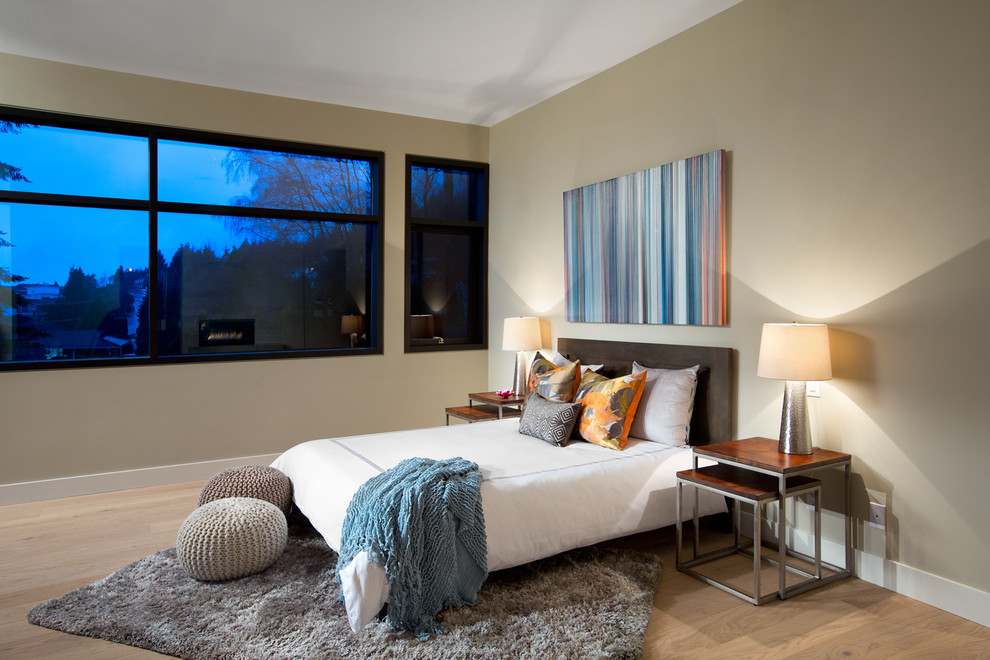 Inspiration for a contemporary master and grey and silver bedroom in Vancouver with a stone fireplace surround.