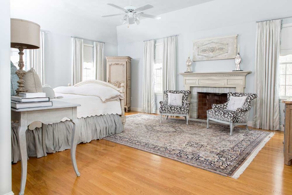 Foto de dormitorio principal clásico renovado de tamaño medio con paredes grises, suelo de madera en tonos medios, todas las chimeneas y marco de chimenea de ladrillo