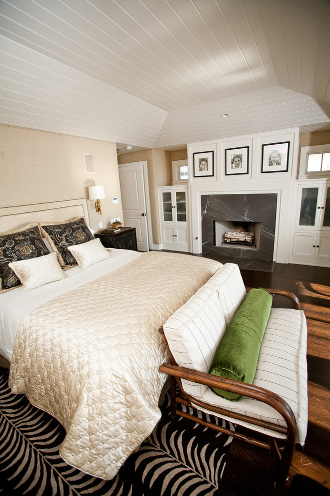 Eklektisches Schlafzimmer mit beiger Wandfarbe, dunklem Holzboden und Kamin in San Diego