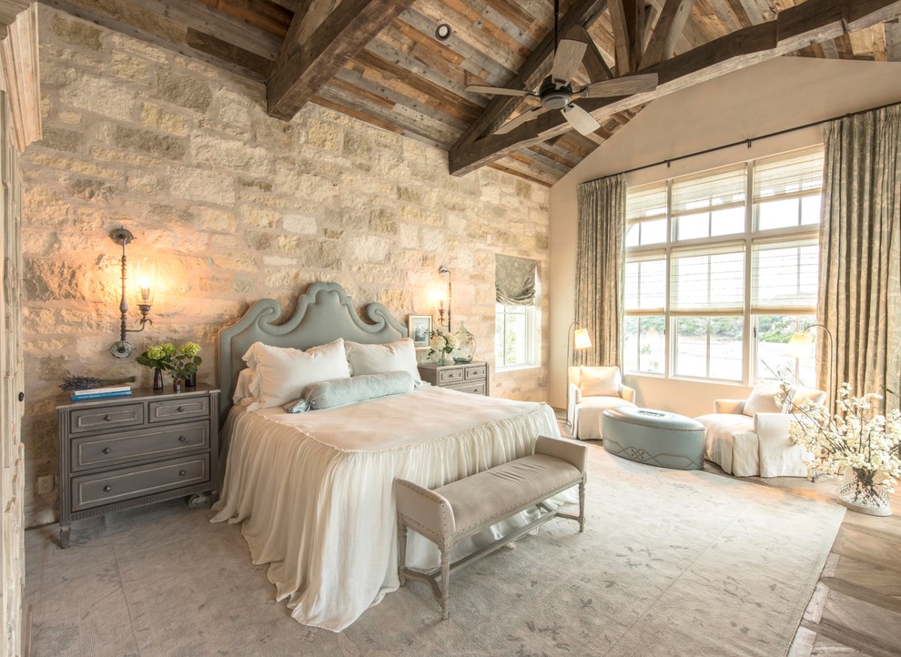 Modelo de dormitorio principal de estilo de casa de campo extra grande con paredes beige, suelo marrón y suelo de madera clara
