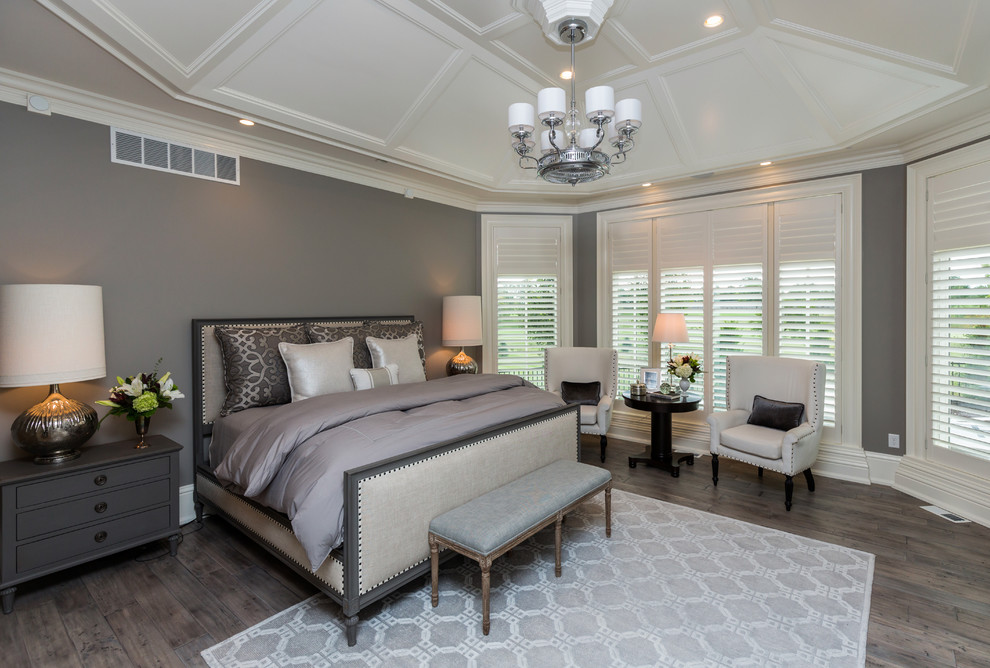 Foto de dormitorio principal clásico renovado grande sin chimenea con paredes grises y suelo de madera en tonos medios