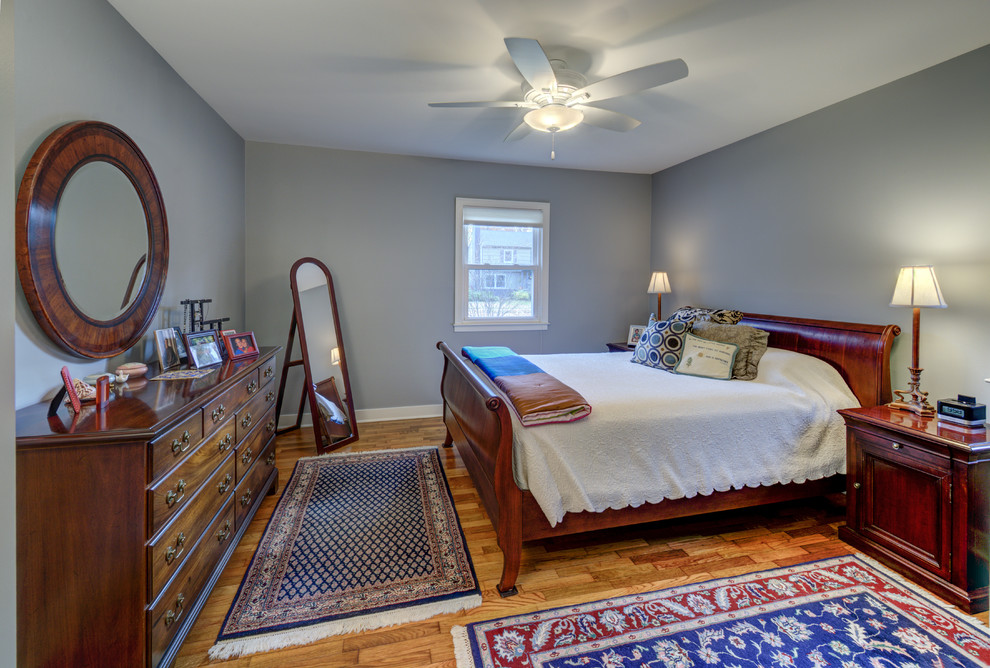 Idee per una camera matrimoniale tradizionale di medie dimensioni con pareti blu e pavimento in legno massello medio