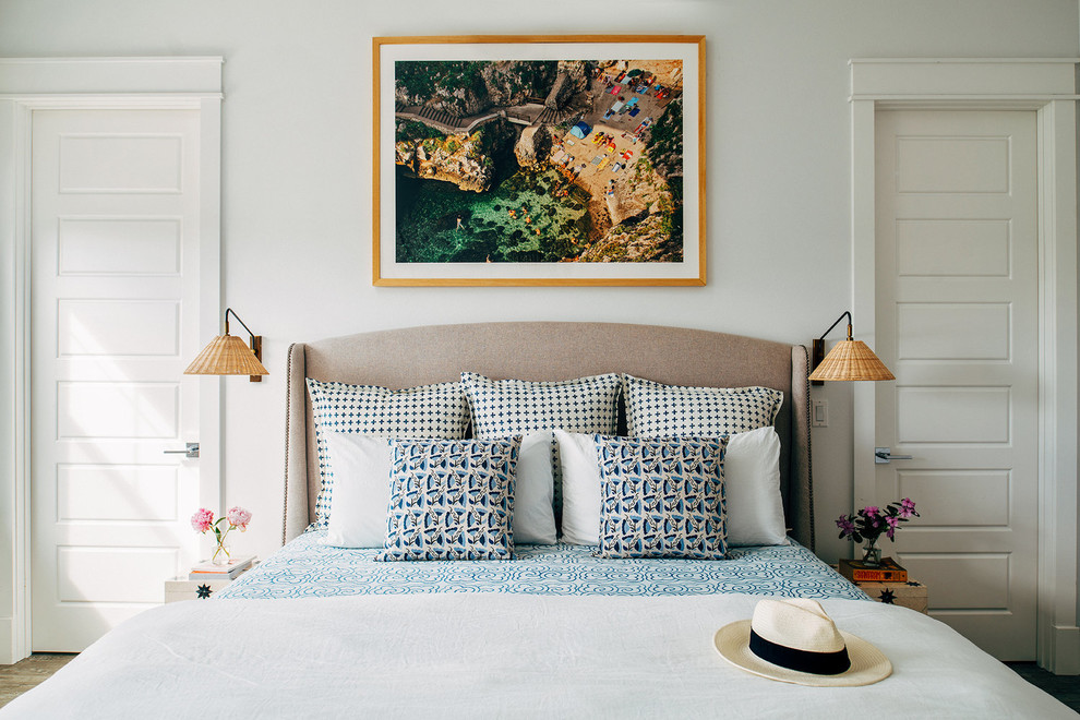 На фото: хозяйская спальня среднего размера в морском стиле с белыми стенами и коричневым полом без камина