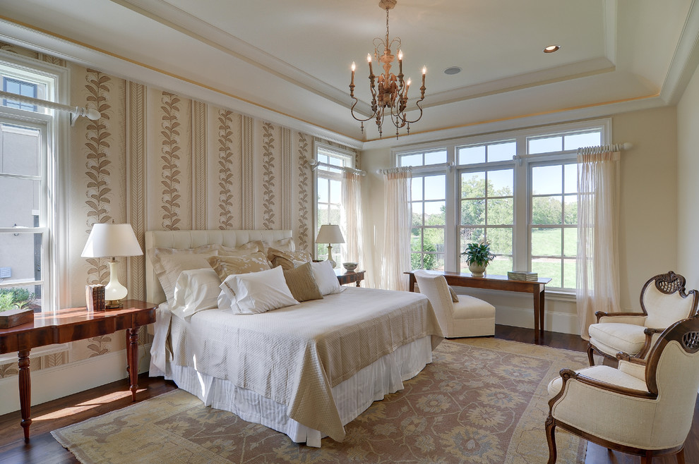 This is an example of a traditional master bedroom in Nashville with beige walls and dark hardwood flooring.