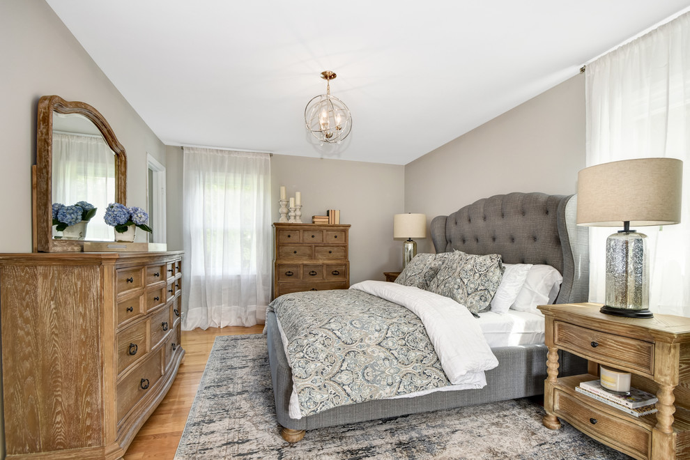 На фото: хозяйская спальня в стиле неоклассика (современная классика) с серыми стенами, светлым паркетным полом и коричневым полом с