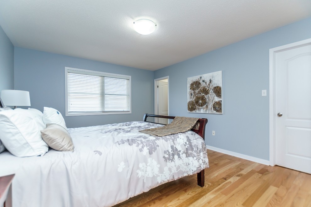 Idée de décoration pour une chambre parentale design de taille moyenne avec un mur bleu, parquet clair et un sol jaune.