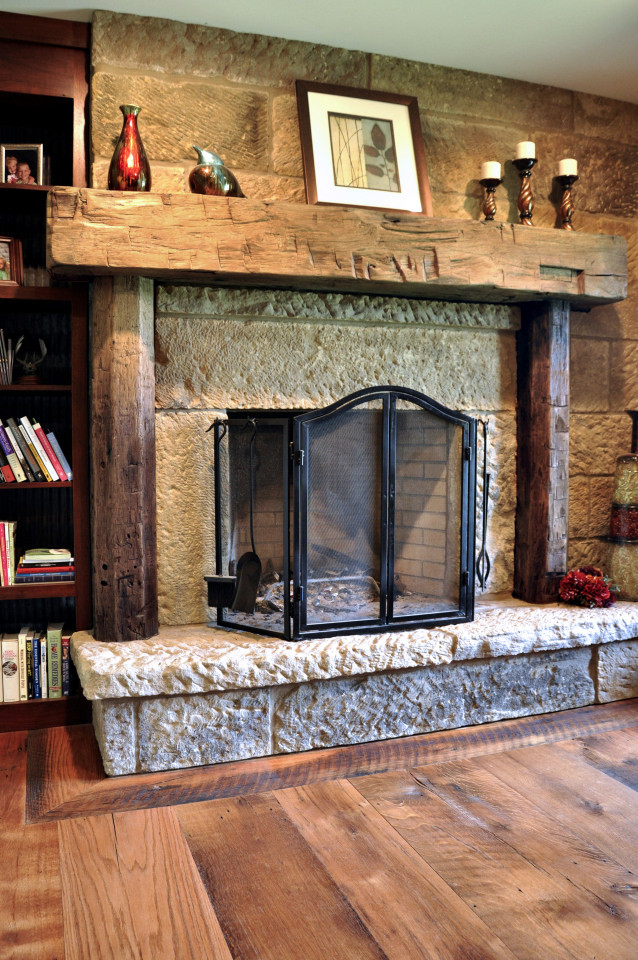 Cette image montre une chambre traditionnelle avec un sol en bois brun, une cheminée standard et un manteau de cheminée en pierre.
