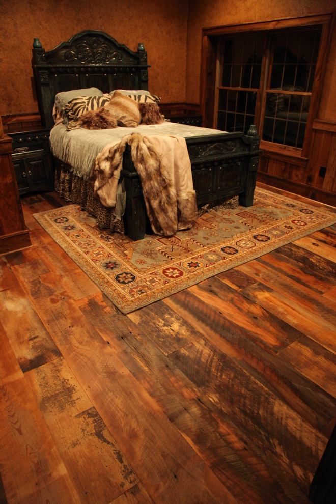 Diseño de dormitorio principal tradicional con paredes marrones y suelo de madera en tonos medios