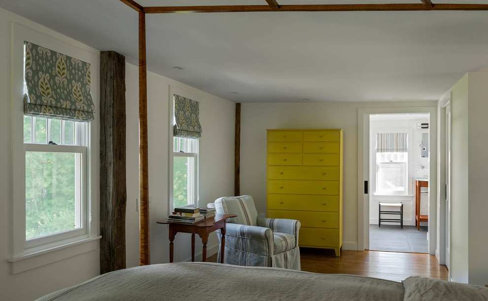 Ejemplo de dormitorio principal ecléctico grande sin chimenea con paredes blancas, suelo de madera en tonos medios y suelo marrón