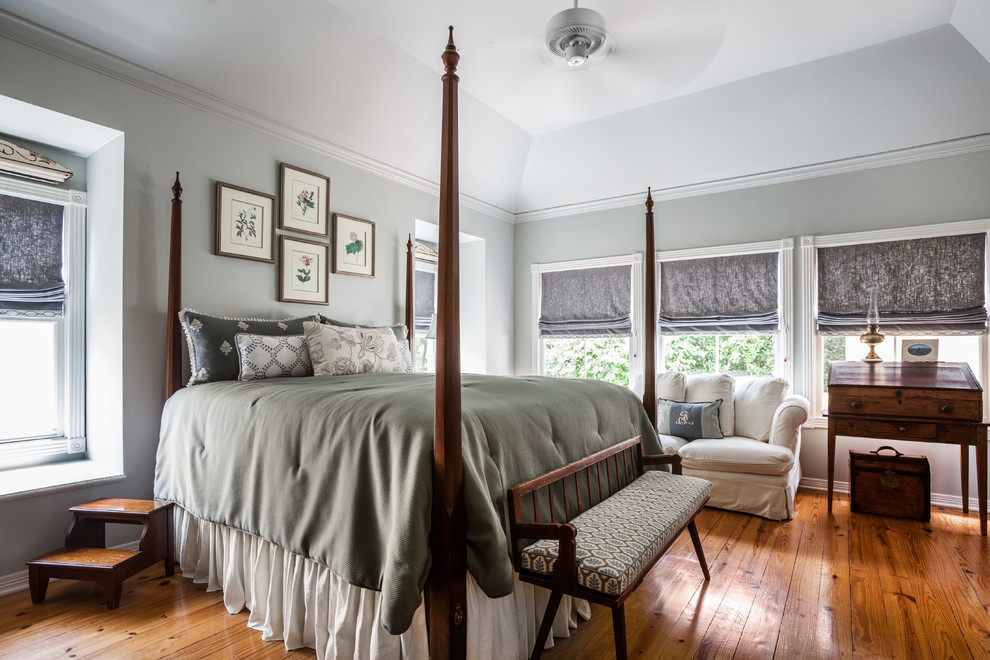 Ejemplo de dormitorio principal tradicional grande sin chimenea con paredes grises y suelo de madera en tonos medios