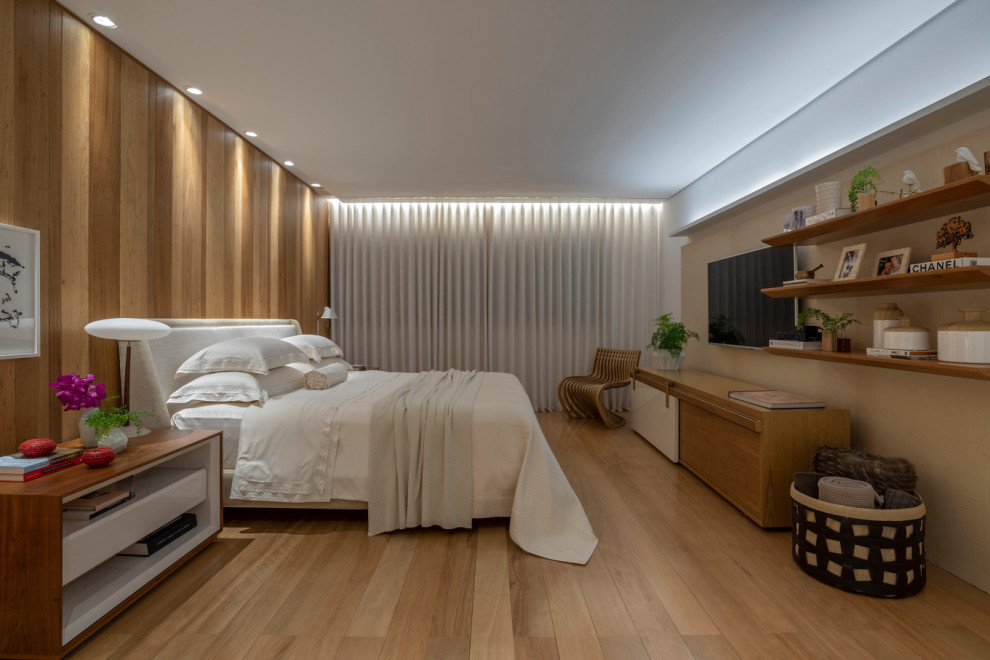 Modelo de dormitorio actual con paredes beige, suelo de madera en tonos medios y suelo marrón