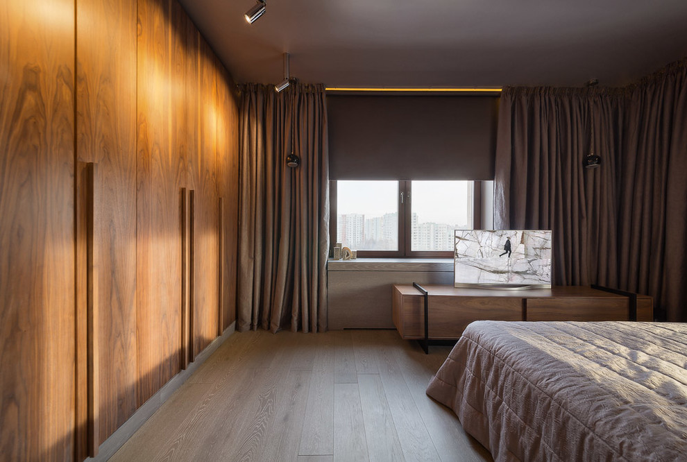 Diseño de dormitorio principal contemporáneo de tamaño medio sin chimenea con paredes grises y suelo de madera clara