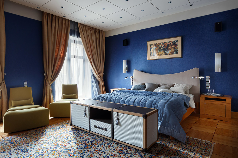 Modernes Hauptschlafzimmer ohne Kamin mit blauer Wandfarbe und braunem Holzboden in Moskau