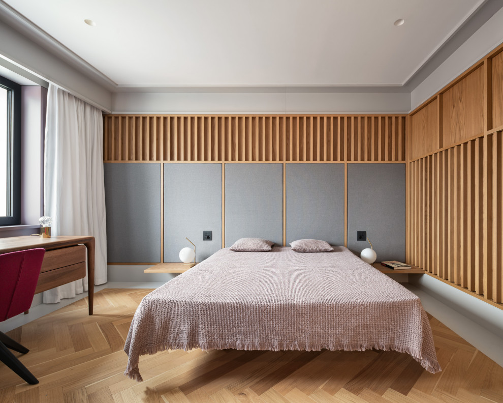 This is an example of a medium sized contemporary master bedroom in London with grey walls, medium hardwood flooring and beige floors.