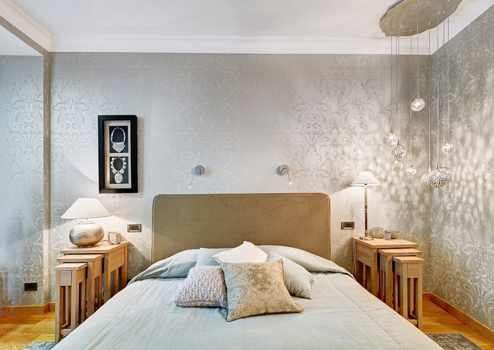 Immagine di una camera matrimoniale design di medie dimensioni con pareti grigie e pavimento in legno massello medio