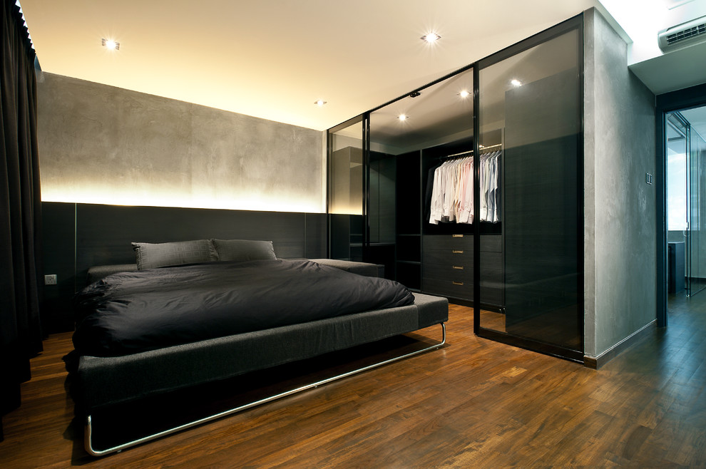 Ejemplo de dormitorio urbano con paredes grises y suelo de madera oscura