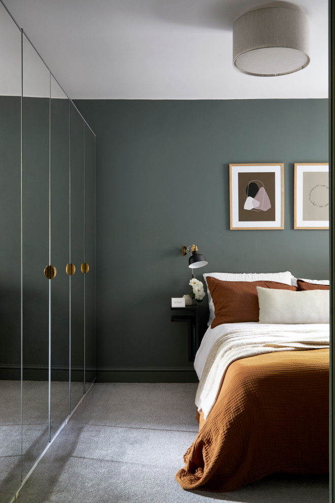 Modernes Schlafzimmer mit grüner Wandfarbe, Teppichboden und grauem Boden in London