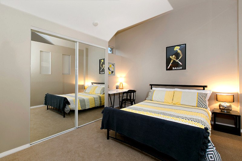 Example of a mid-sized minimalist loft-style carpeted bedroom design in Brisbane with gray walls