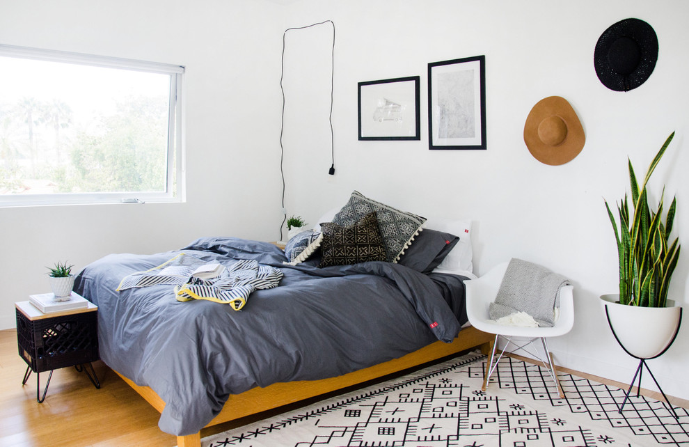 Foto de dormitorio principal bohemio de tamaño medio sin chimenea con paredes blancas y suelo de madera clara