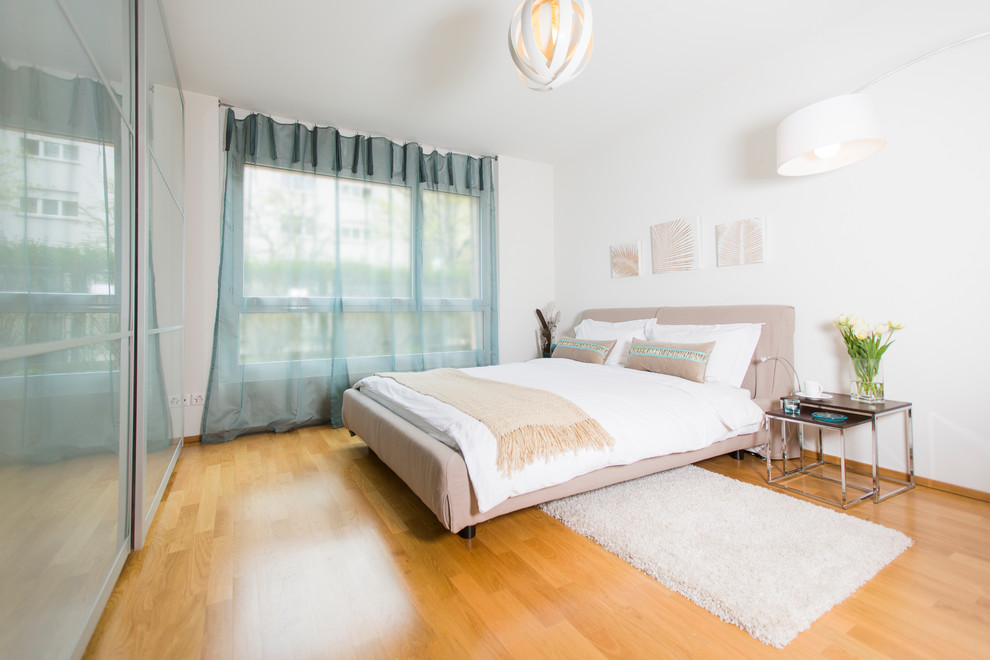 Trendy light wood floor bedroom photo in Other with white walls and no fireplace