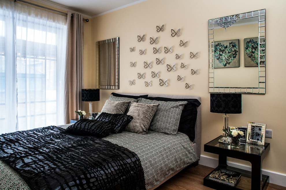 Foto de dormitorio moderno de tamaño medio con paredes beige y suelo de madera clara