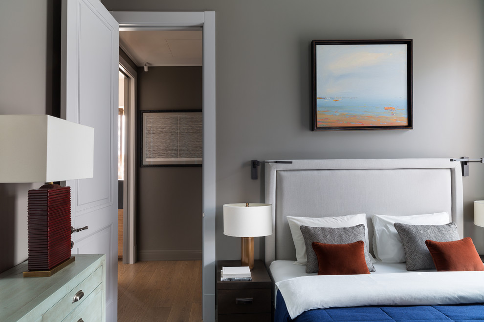 Стильный дизайн: хозяйская спальня: освещение в современном стиле с серыми стенами, паркетным полом среднего тона, коричневым полом и кроватью в нише - последний тренд