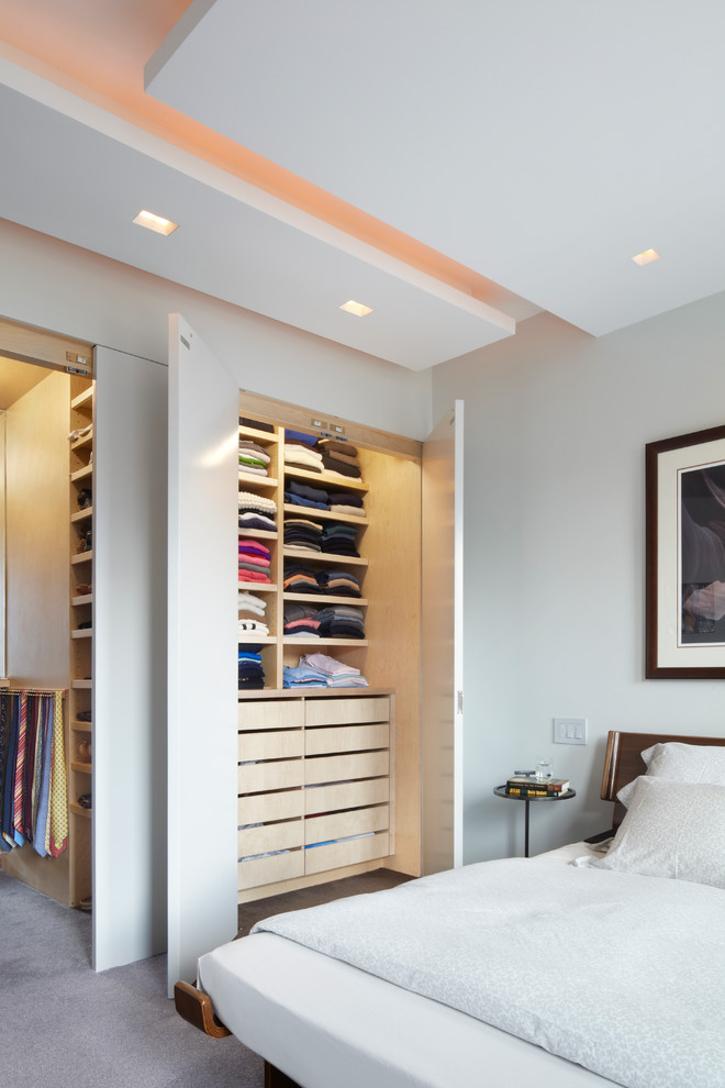 Diseño de dormitorio principal actual de tamaño medio sin chimenea con paredes blancas, moqueta y suelo gris