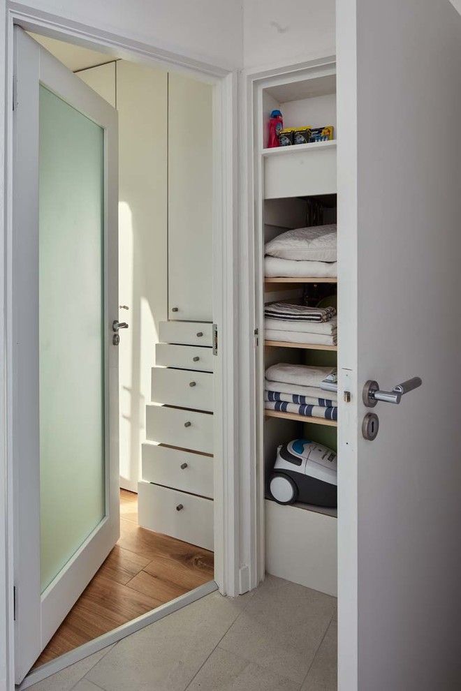 Kleines Modernes Hauptschlafzimmer ohne Kamin mit weißer Wandfarbe und braunem Holzboden in Dublin