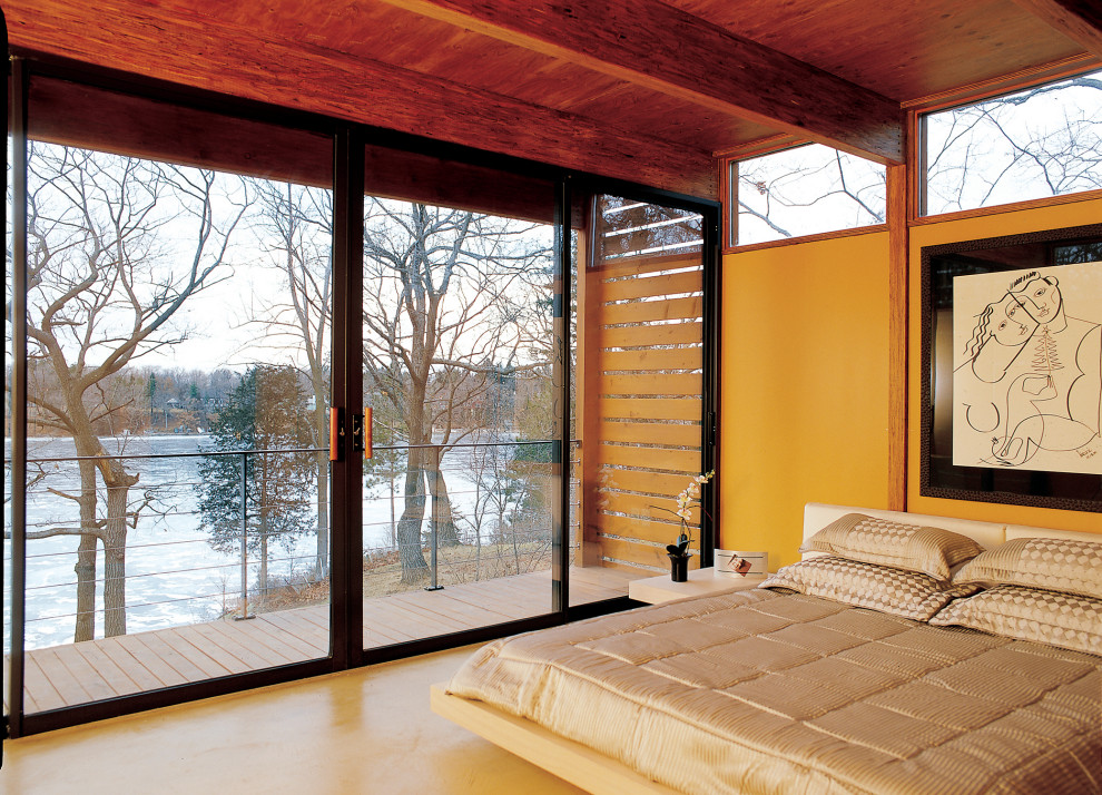 Mittelgroßes Modernes Hauptschlafzimmer ohne Kamin mit gelber Wandfarbe, Betonboden und grauem Boden in Milwaukee