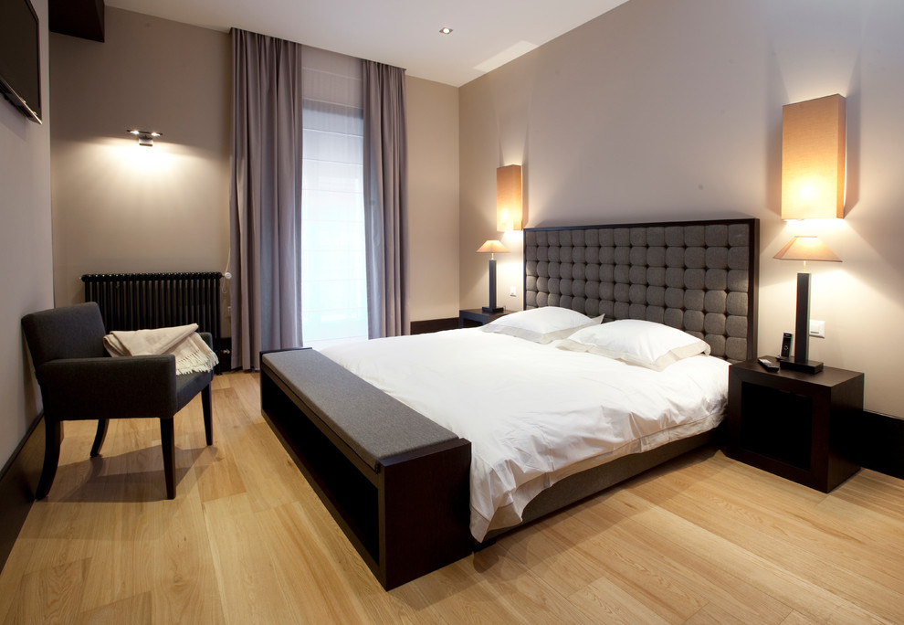 На фото: большая хозяйская спальня в современном стиле с светлым паркетным полом и коричневыми стенами с
