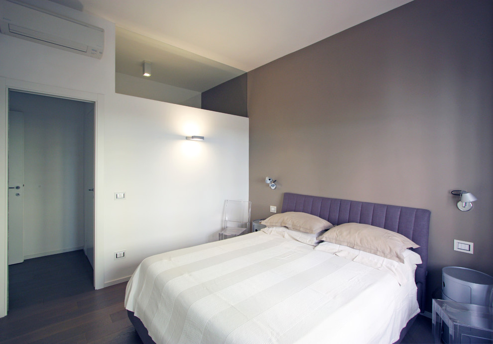 Modelo de dormitorio tipo loft minimalista pequeño con paredes beige y suelo de madera en tonos medios