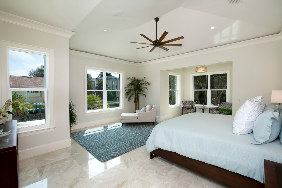 Ejemplo de dormitorio principal tropical grande con paredes blancas y suelo de baldosas de porcelana