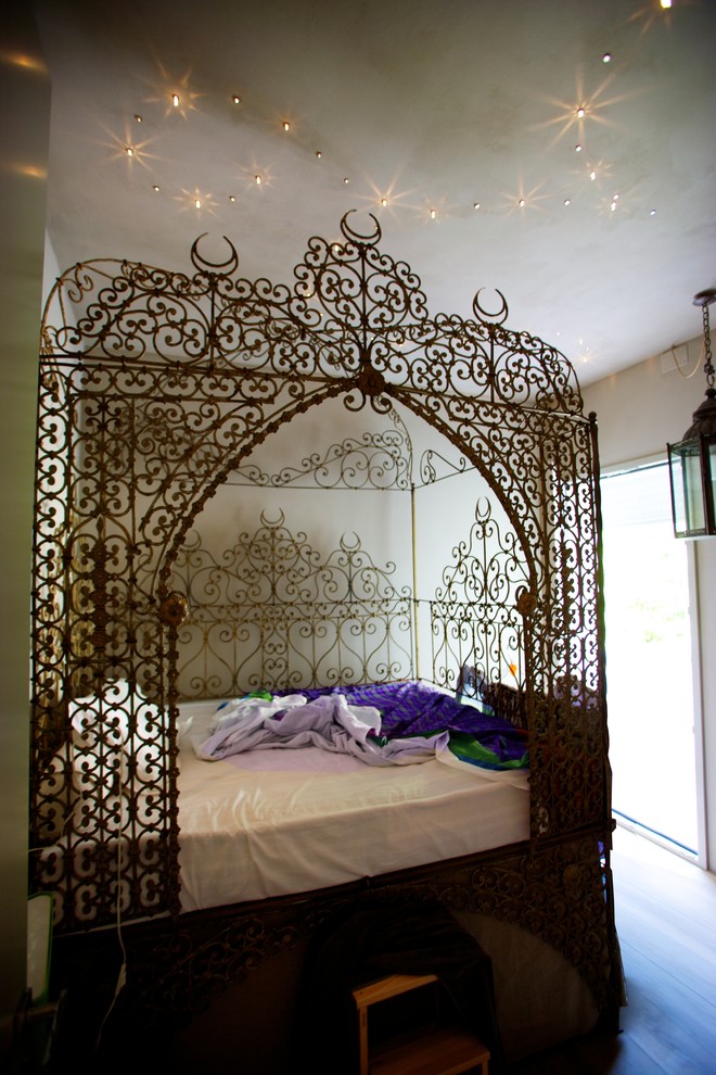 Idee per una camera degli ospiti boho chic di medie dimensioni con pareti beige e parquet chiaro