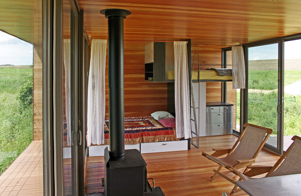 На фото: гостевая спальня (комната для гостей) на мансарде в современном стиле с паркетным полом среднего тона с