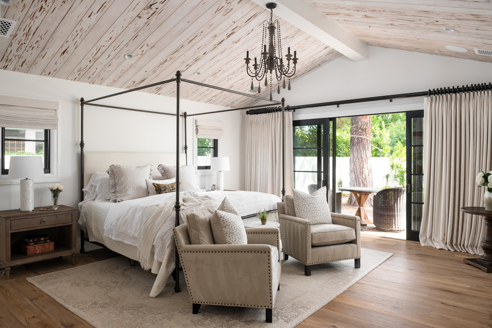 フェニックスにある広いカントリー風のおしゃれな主寝室 (白い壁、無垢フローリング、茶色い床、照明) のインテリア