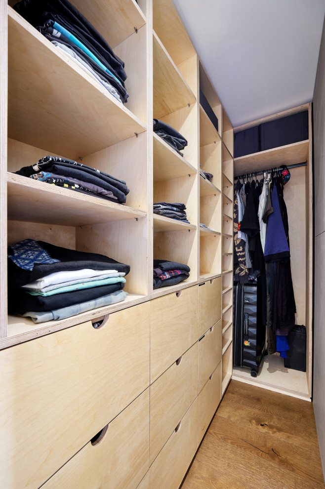 Imagen de armario y vestidor contemporáneo de tamaño medio con suelo de madera en tonos medios y suelo marrón