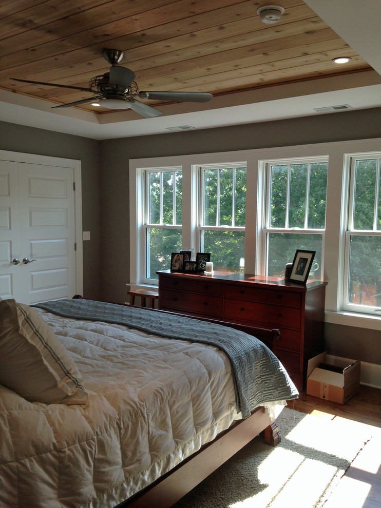 Ejemplo de dormitorio principal campestre de tamaño medio con paredes grises, suelo de madera en tonos medios y suelo marrón