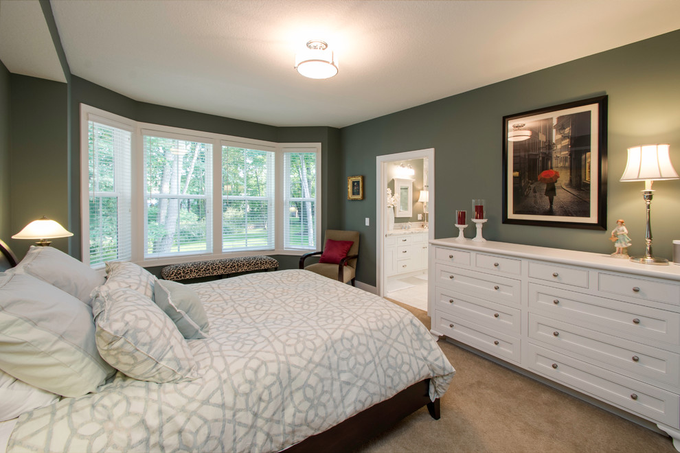 This is an example of a large classic master bedroom in Minneapolis with green walls and carpet.