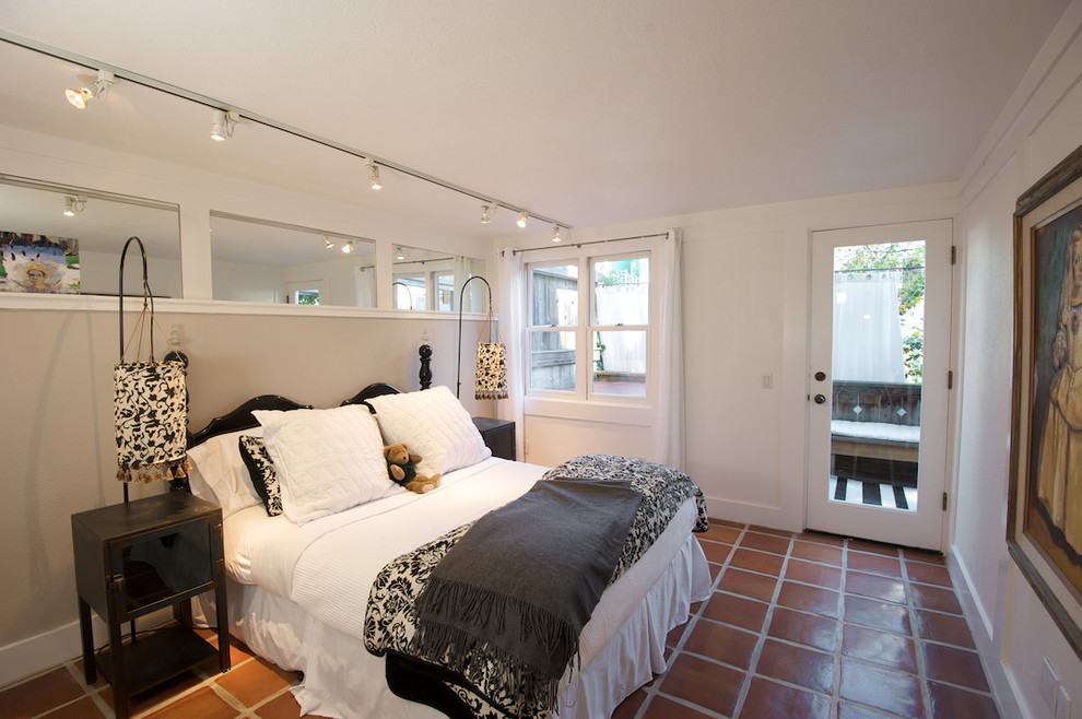 Inspiration for an eclectic bedroom in San Francisco with beige walls, terracotta flooring and red floors.