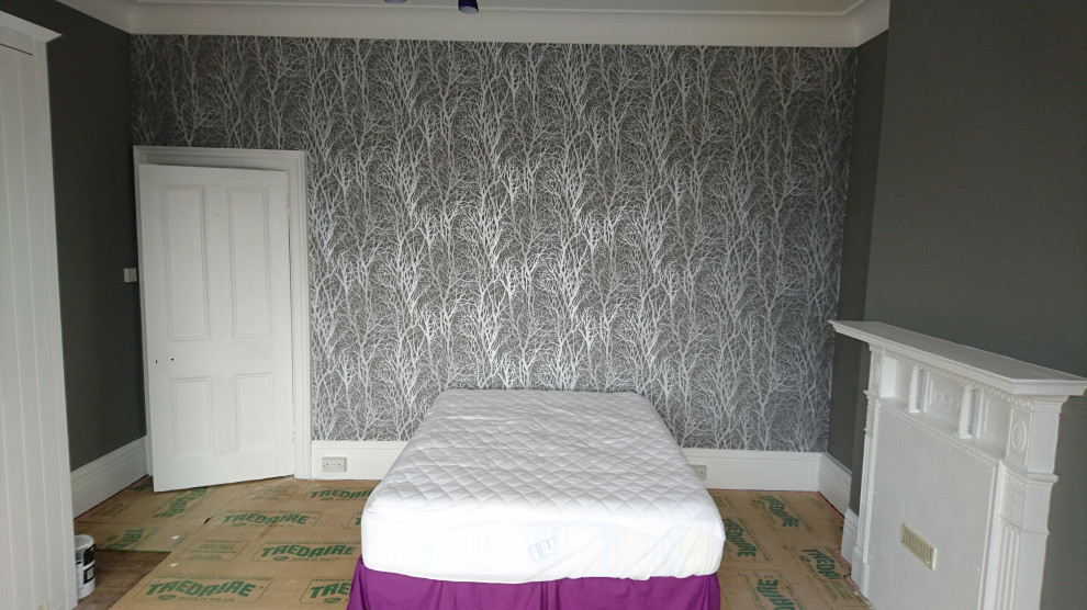 Exemple d'une chambre chic avec un mur gris, un manteau de cheminée en métal et du papier peint.