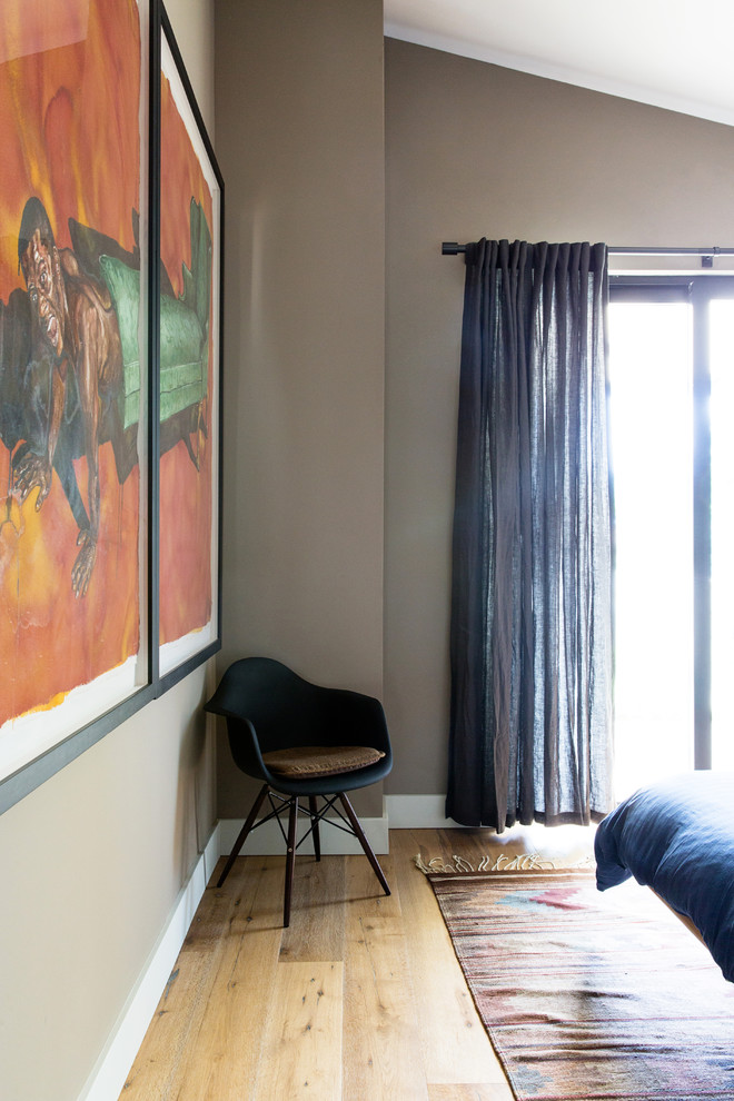 Imagen de habitación de invitados actual de tamaño medio sin chimenea con paredes beige, suelo de madera en tonos medios y suelo beige