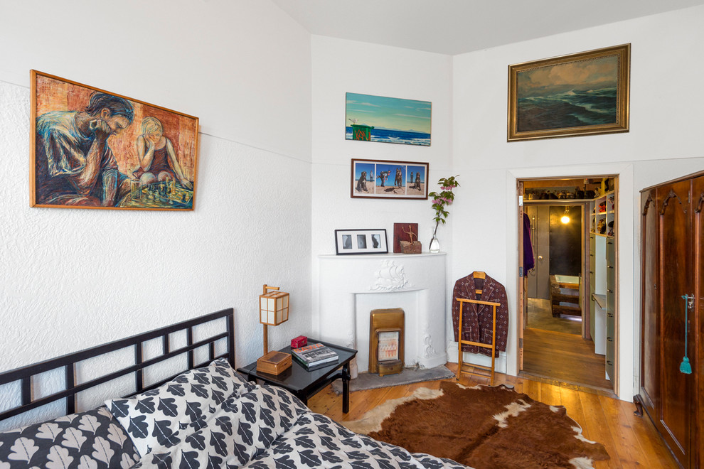 Foto de dormitorio ecléctico con paredes blancas y suelo de madera en tonos medios